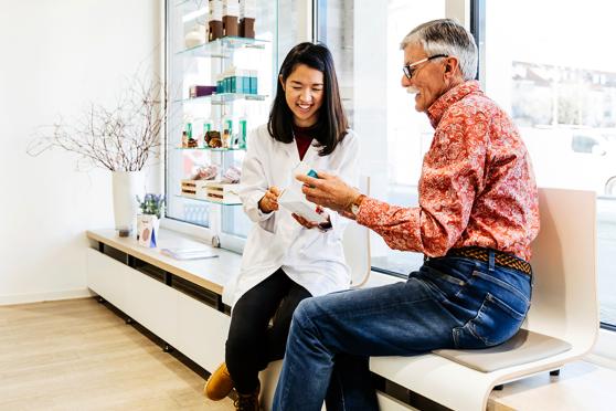 Man discussing medication with female pharmacist